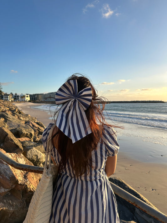Person wearing a striped hat and dress on a beach