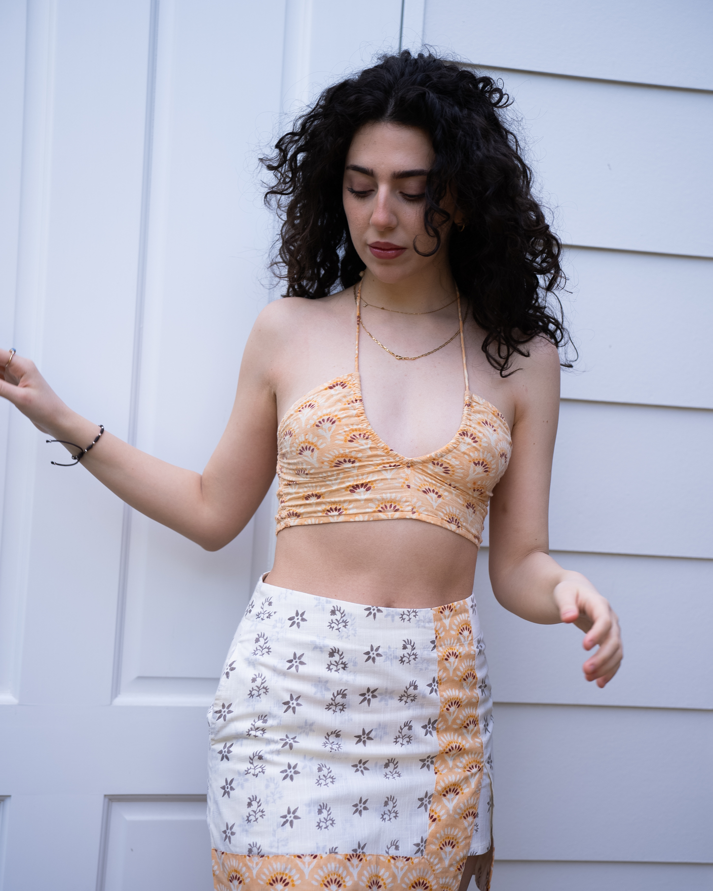 Front view of Jaipur halter crop top with Sunrise high-waist mini skirt, orange floral block print and white base panel