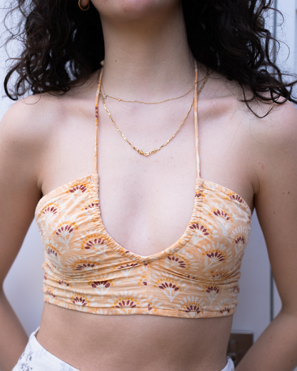 Close-up of Jaipur halter crop top neckline and hand-block print detail in warm orange tones 